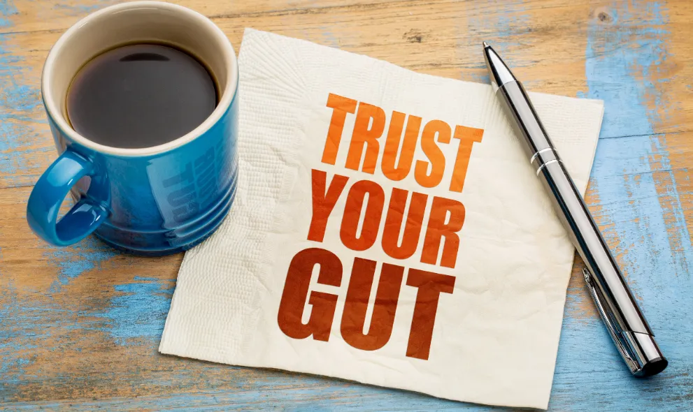 Trust your gut word abstract with cup of coffee and pen