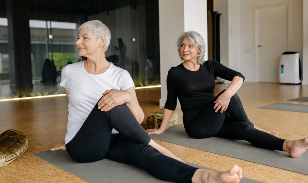 Two women sitting on yoga mats