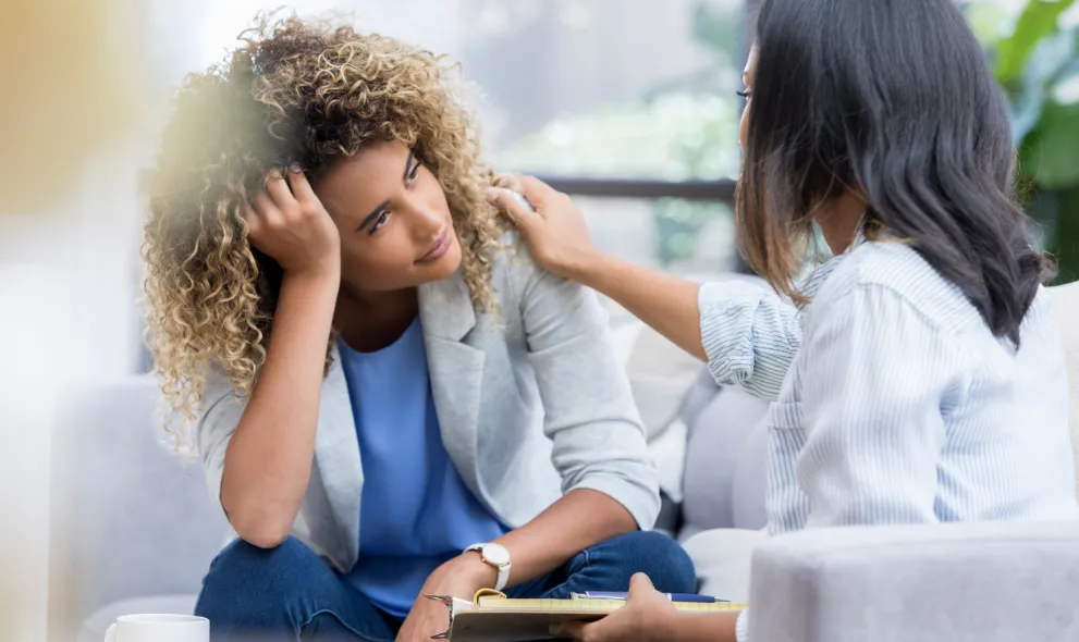 Upset woman talks with mental health professional