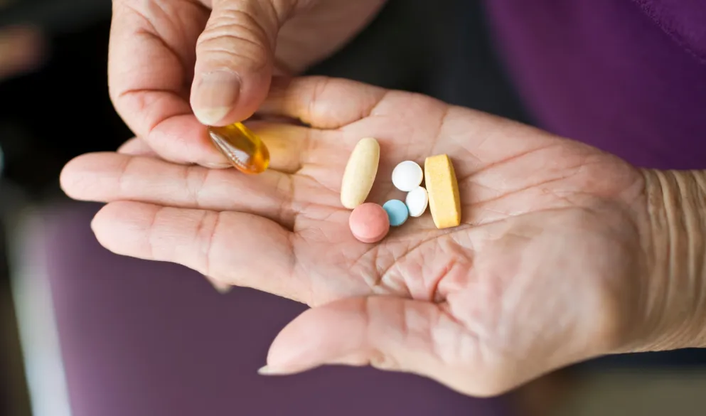 Variety of medication in the palm of elderly senior woman