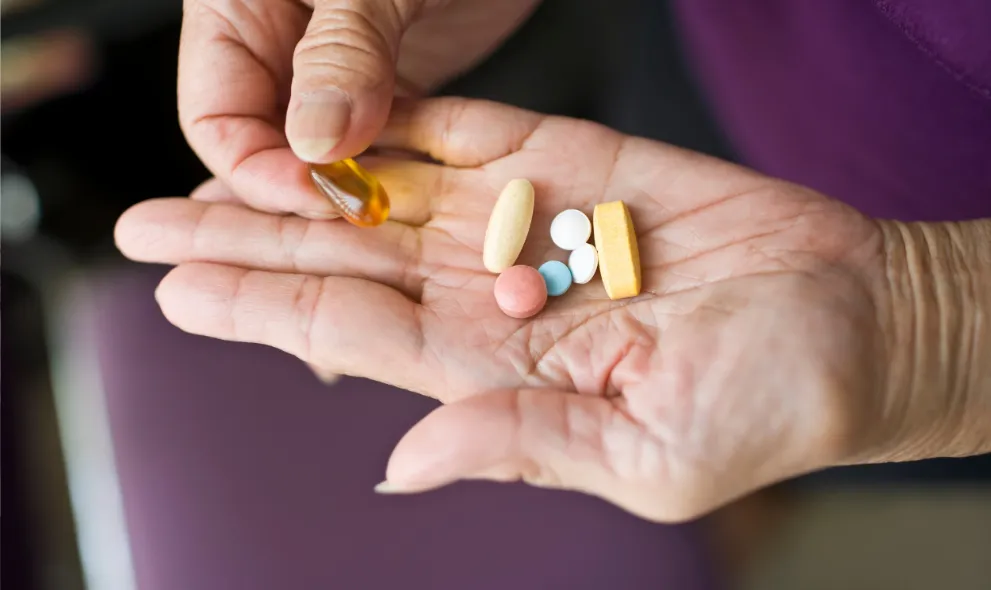 Variety of prescription medications in the palm of senior woman