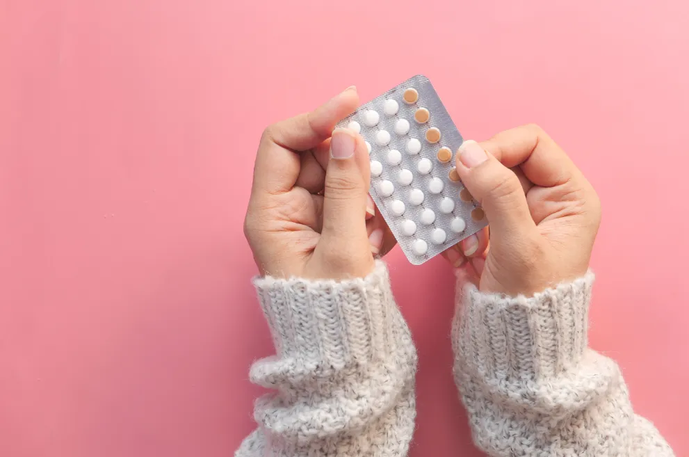 Woman's hands holding pack of pills