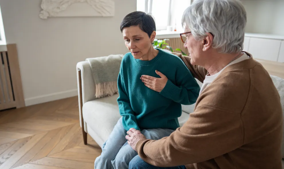 Woman clutches heart as man holds hand