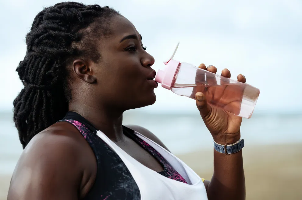 Woman drinking from water bottle during workout