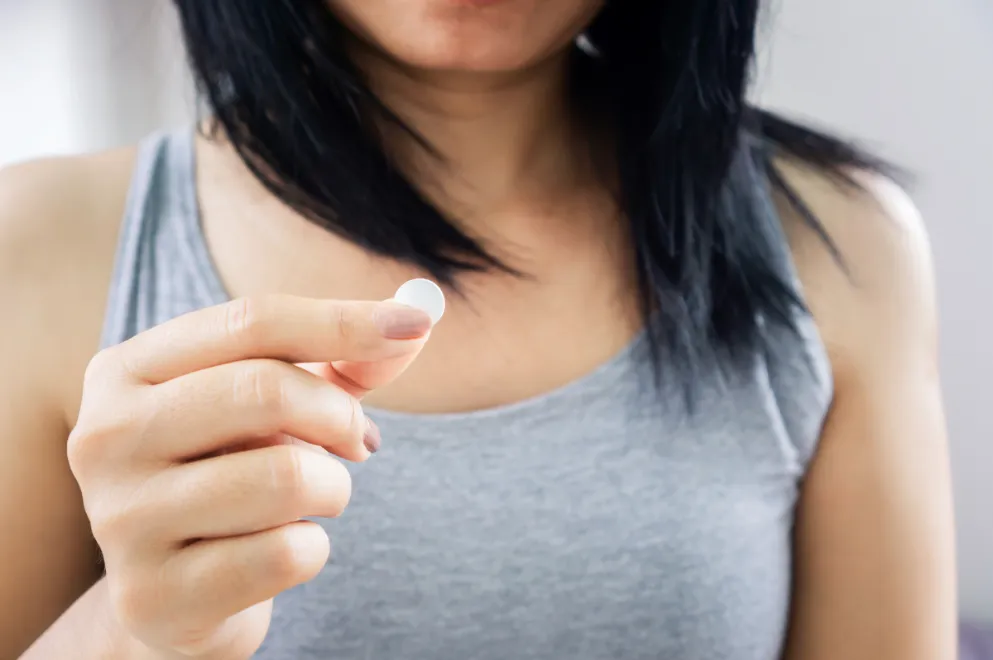 Woman holding heartburn tablet