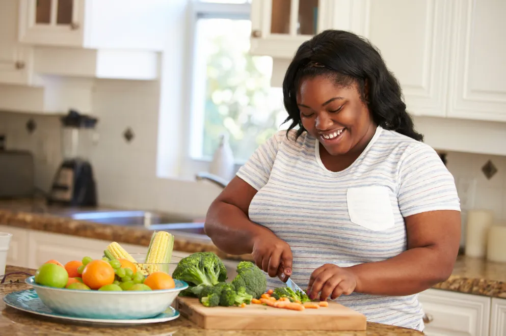 Woman in kitchen preparing vegetables