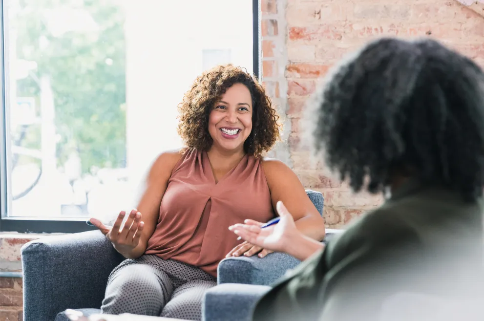 Woman speaking with therapist and smiling