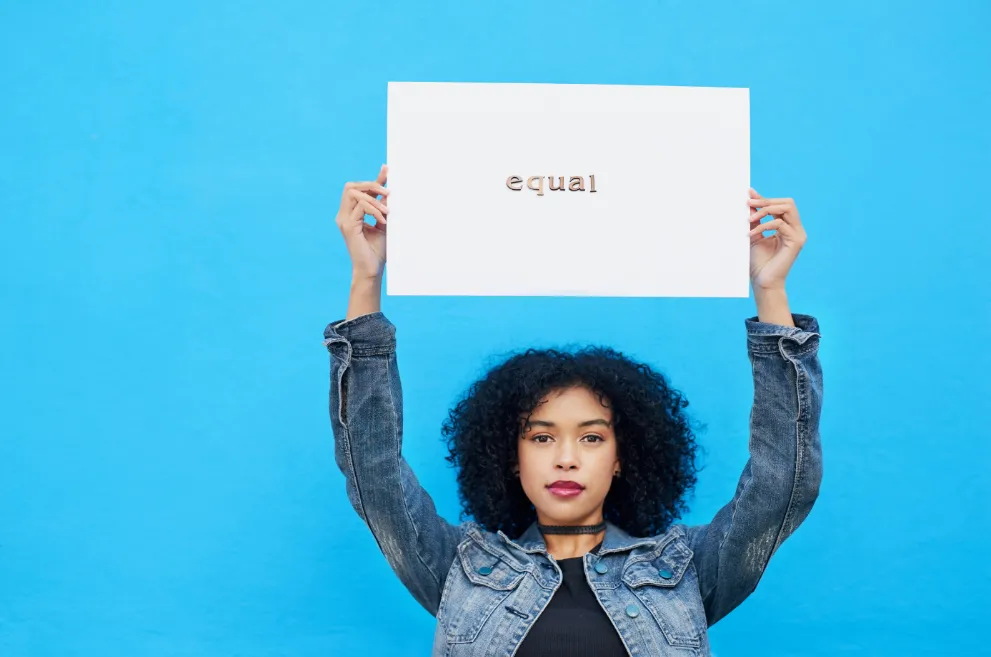 Young Black woman holding sign with word equal