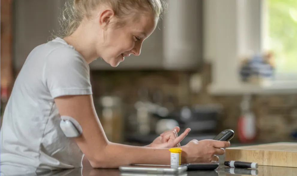 Young woman checking her sugar levels in kitchen