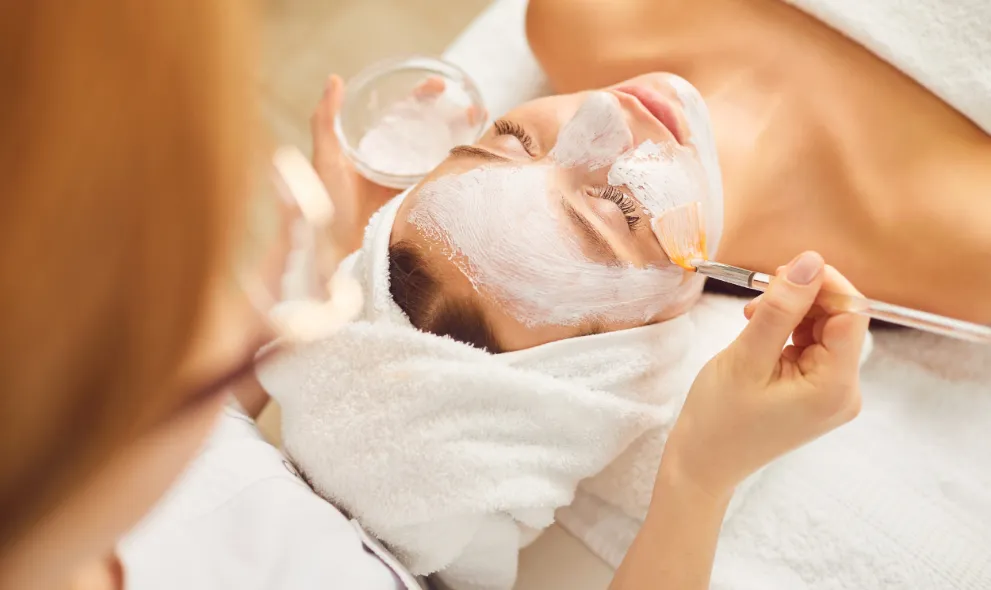 Young woman receiving a facial mask